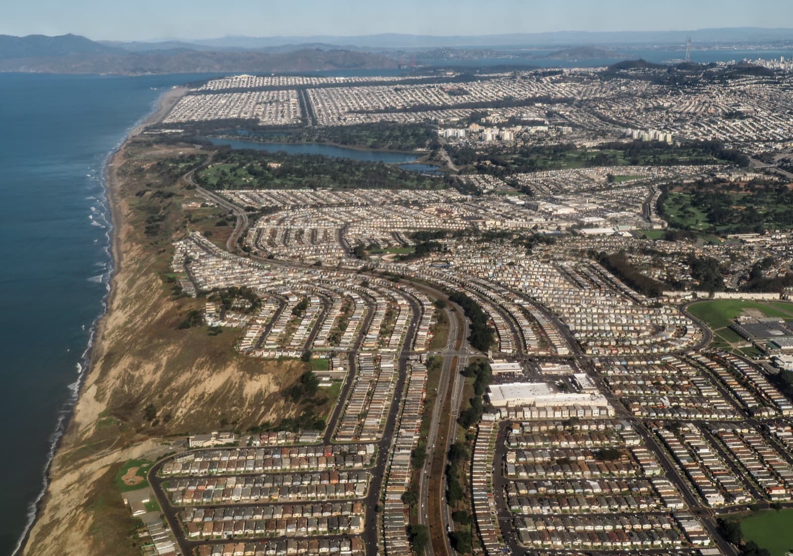 Aerial view of dense rows of small postwar tract homes in Daly City, California, along the Pacific coast