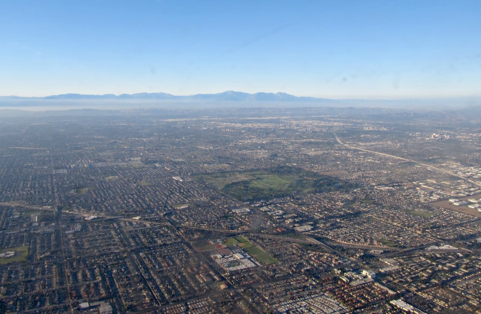 Aerial view of vast single-family suburban sprawl in Fountain Valley, California, with mountains on the horizon