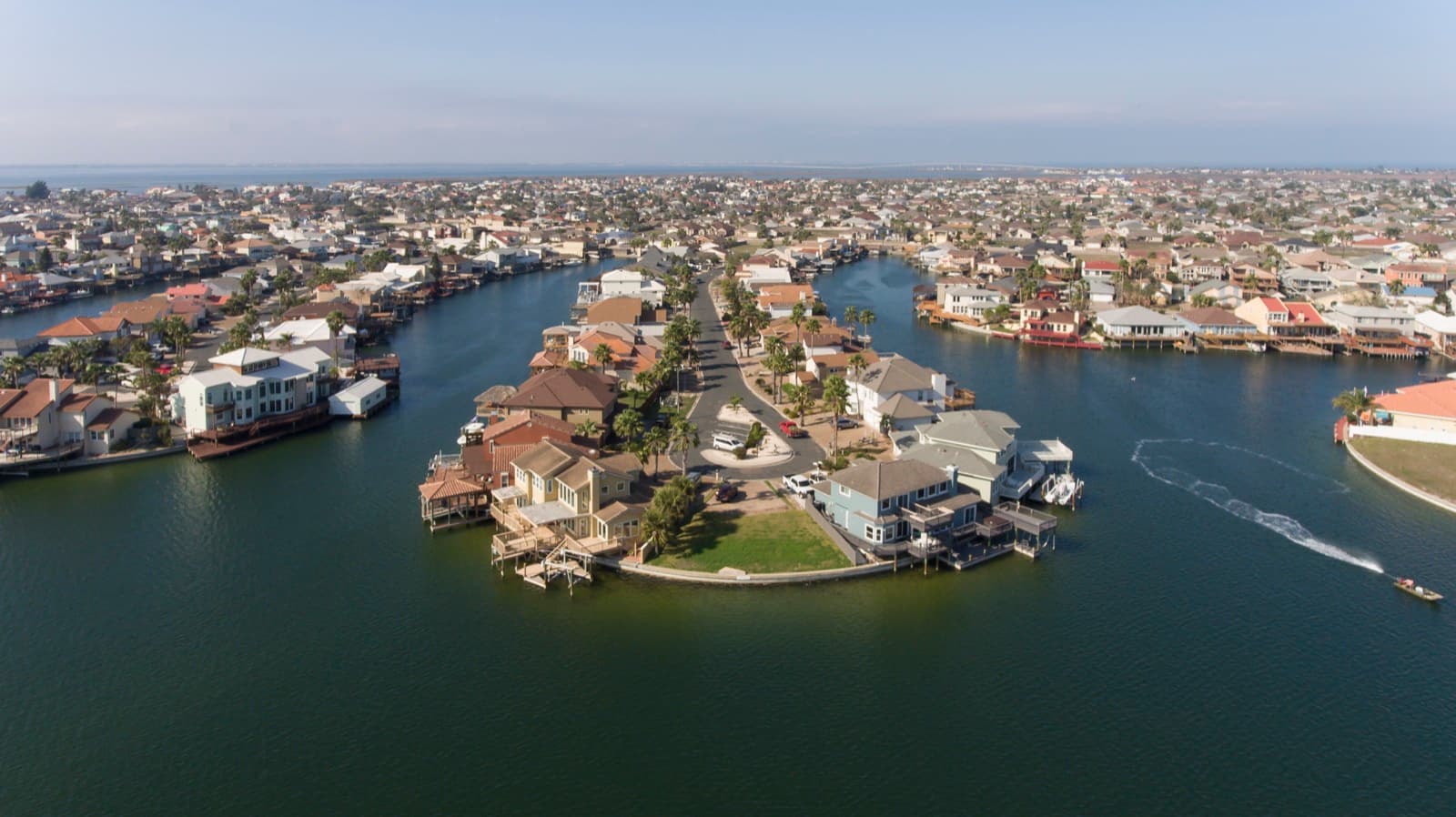 Aerial view of a waterfront residential neighborhood of single-family homes on Padre Island, Texas
