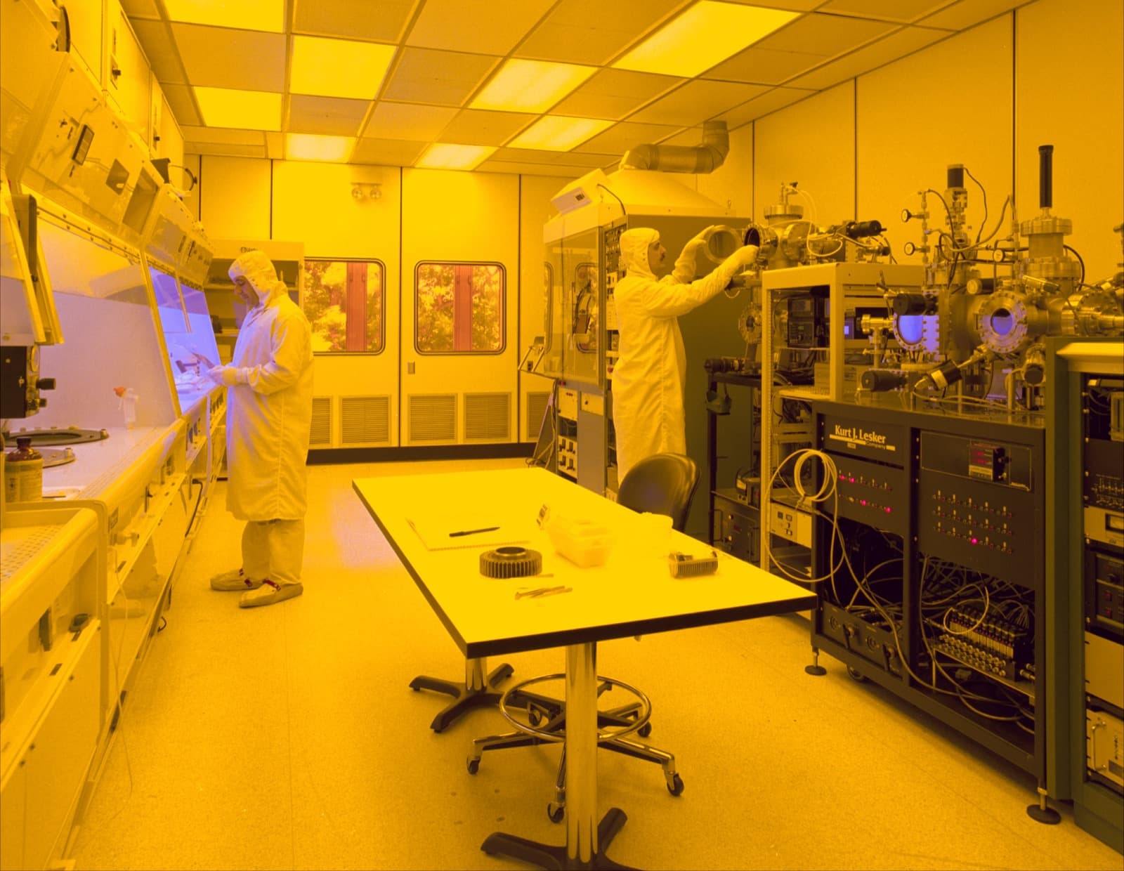 Workers in protective suits inside a semiconductor manufacturing cleanroom
